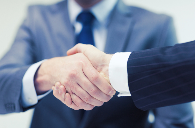 A firm handshake representing a long-term, trust-based partnership with JOYKOREA.